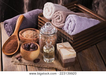 Natural cosmetic cacao butter, sea salt and natural handmade soap with cocoa beans on rustic wooden background. Healthy skin care. SPA concept.