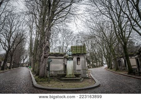 PARIS, FRANCE - DECEMBER 22, 2017: Graves from the 19th century in Pere Lachaise Cemetery in Paris, France, during a cold cloudy winter afternoon. Pere Lachaise Cemetery is the largest cemetery in Paris, hosting major french celebrities