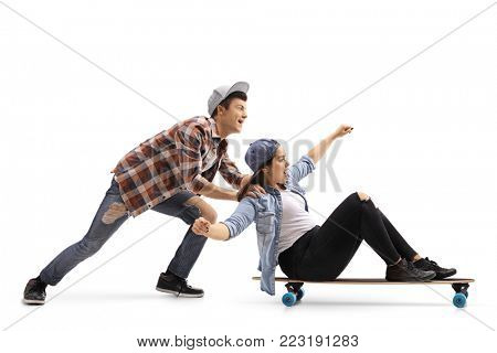 Teenage boy pushing a teenage girl on a longboard isolated on white background