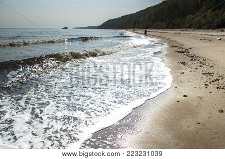 Photo taken on the banks of the St. Lawrence River, Forestville, Quebec, Canada in September 2008. Walking on the sand on a beautiful day ahead is very pleasant.