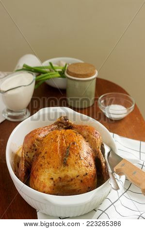 Baked chicken with herbs and garlic, served with sour cream sauce. Rustic style, selective focus.
