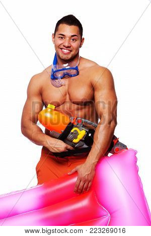 Portrait of muscle man posing in studio with water gun and mattress