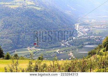 Chairlift, apple trees and mountain panorama in Algundo, South Tyrol