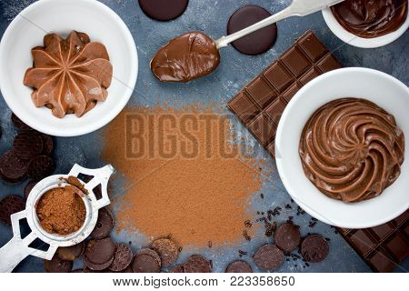 Chocolate background - chocolate ganache, melted chocolate, chocolate cream frosting, cocoa powder empty space for text top view