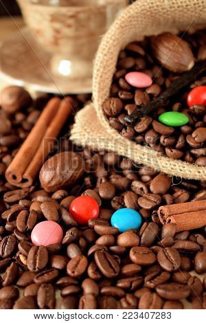 Coffee beans, multicoloured drops, cinnamon and vanilla. Ingredients for making a drink