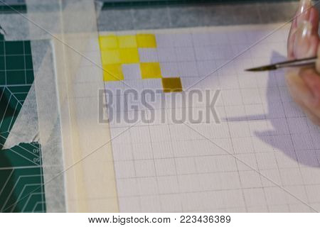 The artist's hand lies on the unfinished drawing. In his hand a brush for watercolor.
