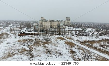 Grain Terminal In The Winter Season. Snow-covered Grain Elevator In Rural Areas. A Building For Dryi