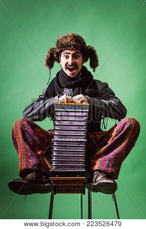 A Very Positive Man With An Accordion Posing In The Studio