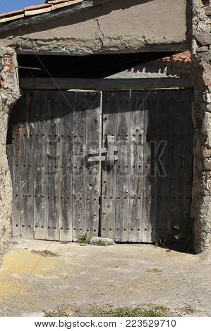 Old wooden door, weathered by time. Framed by a cracked wall
