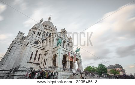 White marble Sacre-Coeur Basilica with tourists, long exposure, blurred people, Paris