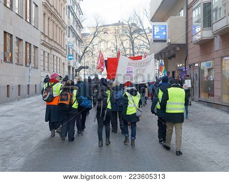 STOCKHOLM, SWEDEN - JAN 21, 2018: Rear view of people holding banner in the Womens March, a worldwide protest for women's rights in central Stockholm, Norrmalmstorg, Sweden, January 21, 2018