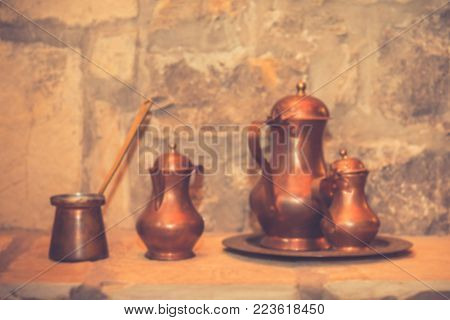 Antique brass retro teapot and coffee set. Vintage filter effect. Copy space. Blur rustic background.