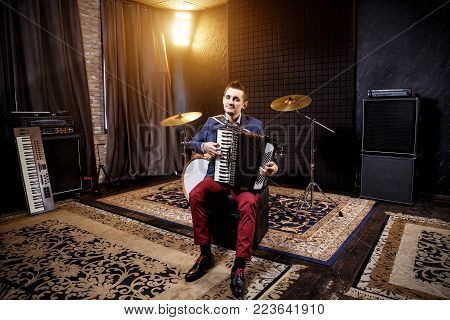 Accordionist in the recording studio. Shock and amplifiers in the background