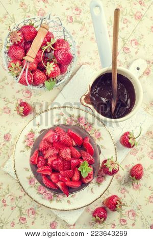 Traditional chocolate strawberry cheesecake with fresh strawberries as top view on a plate - vintage