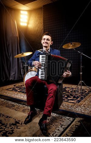 Accordionist in the recording studio. Shock and amplifiers in the background