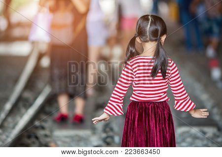 Rear view of modern little girl, standing.