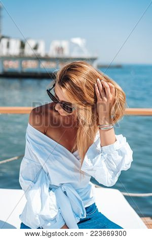 beautiful woman in a white blouse by the sea on a beach bed