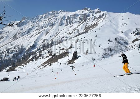 Skier Skiing Downhill On A Blue Piste In Passo Pordoi, Italy