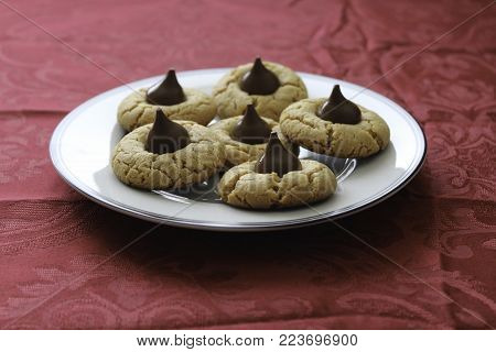 Homemade peanut butter cookies on white plate. Red tablecloth on table
