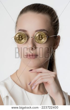 Young beautiful girl in glasses from bitcoin on white background
