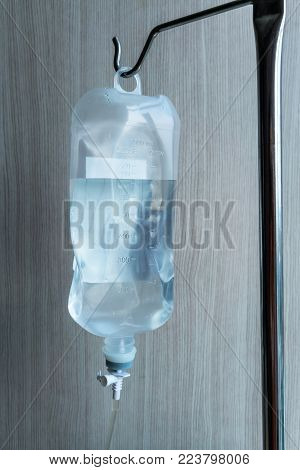 Normal saline solution for patient in the hospital against wooden background