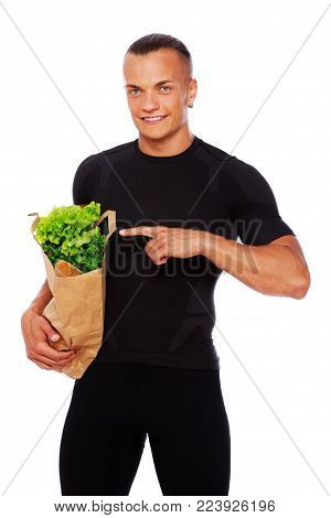 Portrait of handsome man standing in store with food
