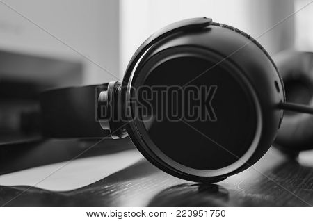 Black pair of headphones close-up, black and white images.