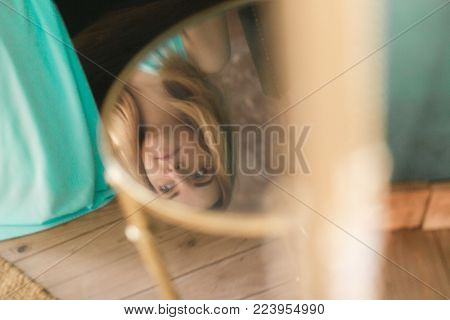 Woman reflection in glass table at home.