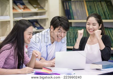 Group Of Student Seaching Information In The Library With Attractive Smiling Together. People With E