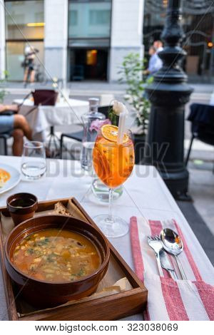 Glass Of Aperol Spritz Cocktail, Water And Famous Hungarian Soup Gulyas On The Table In Street Resta