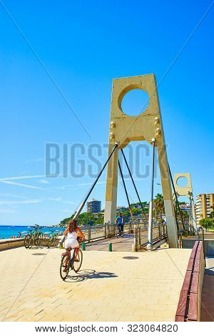 San Antonio De Calonge, Spain - August 21, 2018. Cyclists Crossing The Puente De Valentina Bridge, O