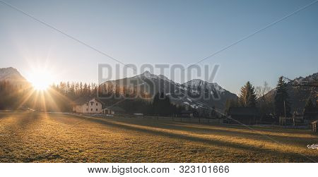 Winter Panorama In The Alps Mountains. Sunset Over Alpine Village On A December Evening, In Ehrwald,