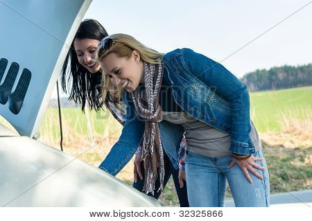 Le donne di ripartizione auto guardando sotto cappa tentano di riparare il motore