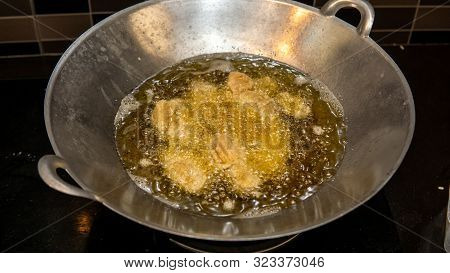 Close Up View Of The Frying Chicken In A Hot Boiling Oil In The Metal Wok.