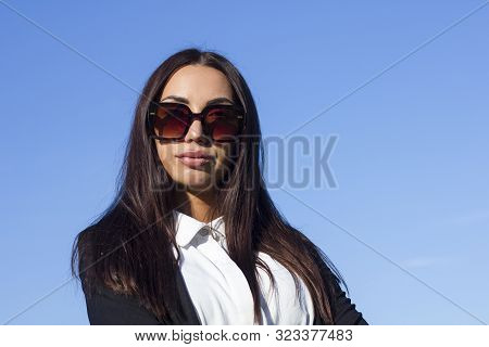 Glamorous Brunette Stylish Girl In Sunglasses With Big Puffy Lips Looking At The Camera On A Backgro