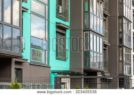 Closeup Of Apartment Building Wall With Glass Windows And Balconies