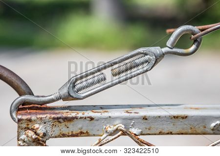 Turnbuckle On Rusted Iron Fence With Blurred Background