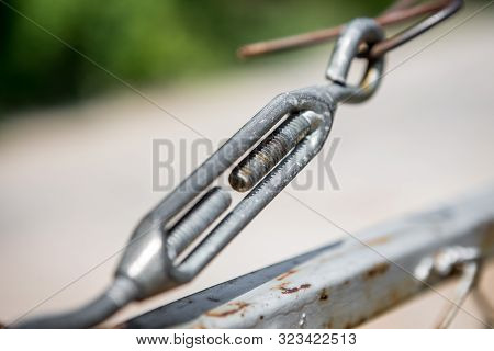Turnbuckle On Rusted Iron Fence With Blurred Background