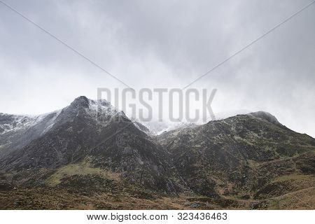Stunning Moody Dramatic Winter Landscape Mountain Image Of Snowcapped Y Garn In Snowdonia