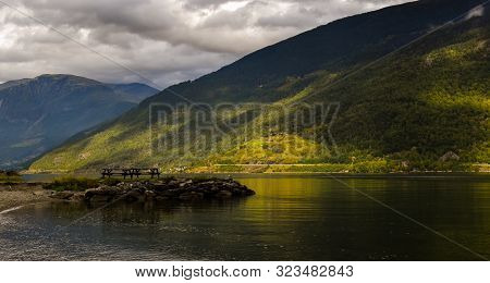 Park Bench With The Backdrop Of The Beautiful Fjord In Flam With The Light Of Summer Shining Through