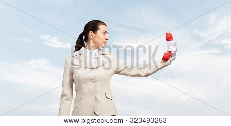 Businesswoman Holds Vintage Red Phone On Distance. Serious Operator In Business Suit Posing With Tel