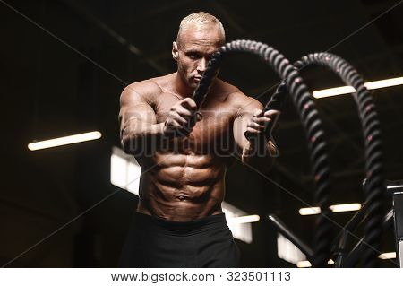 Fitness Athletes Training Using Battle Ropes Intense Workout Team Exercise Challenge In Gym Enjoying