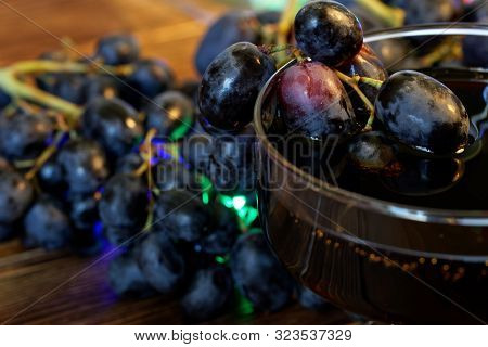 Black And Red Grapes And Homemade Wine, Juice Or Tincture In A Wide Transparent Glass. Farm Harvest 
