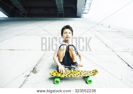 Little Cute Boy With Skateboard On Playground Alone Training, Making Funy Faces
