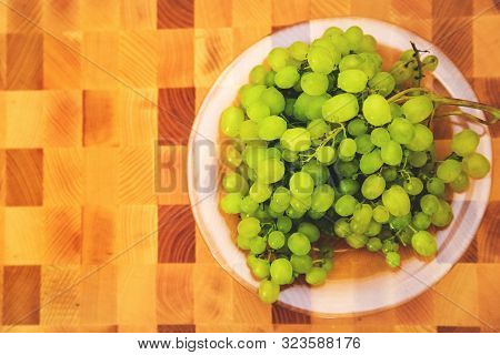Fresh Green Grape On The Plate On The Wooden Cutting Board, Top View