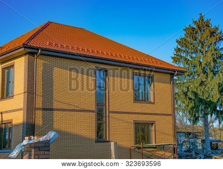 Two-storey House With Long Vertical Window On The Stairwell, Rain-gutter And Show-guard On The Metal