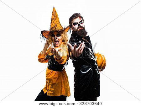 Halloween Surprised Woman And Handsome Bearded Man In Halloween Hat And Costume Holding Pumpkin