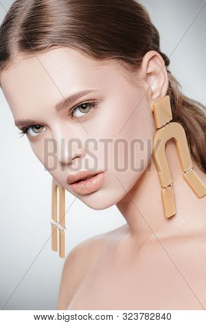 Fashion beauty portrait.  Attractive fashion model posing in earrings in the avant-garde style.