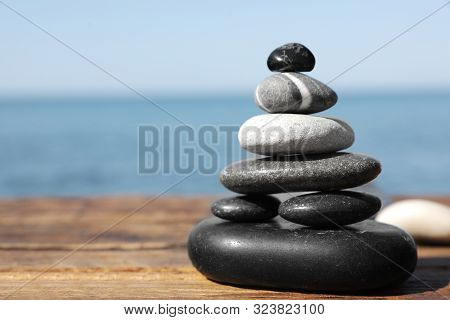 Stack Of Stones On Wooden Pier Near Sea Seascape, Space For Text. Zen Concept