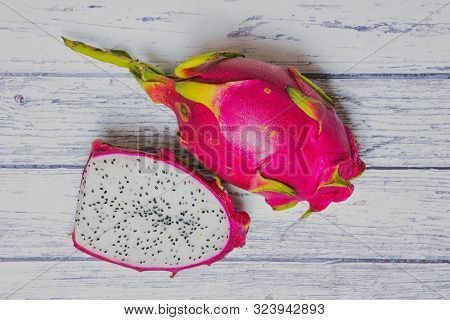 Dragon Fruit Half Beside A Pink Dragon Fruit On White Wooden Background